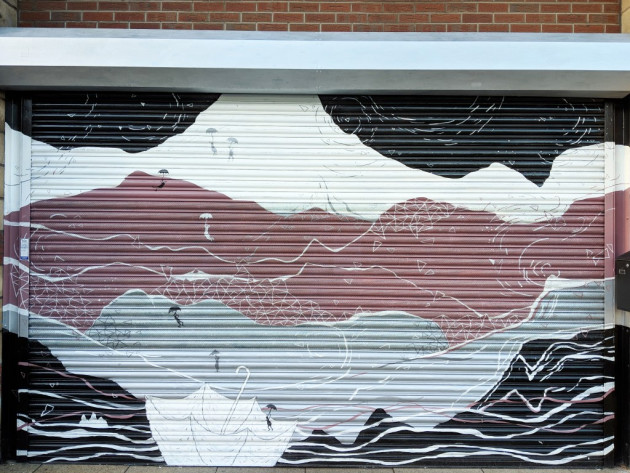 Metal shutters painted with a mountain scene and people flying around with open umbrellas